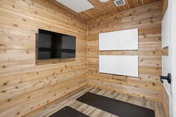 A room with wooden walls and a flat screen TV mounted on the wall.